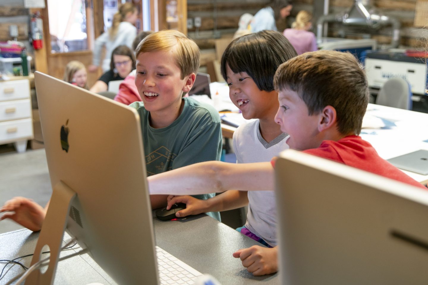 Three children collaborating at a computer during the Adventures in Animation workshop at Anderson Ranch Arts Center.