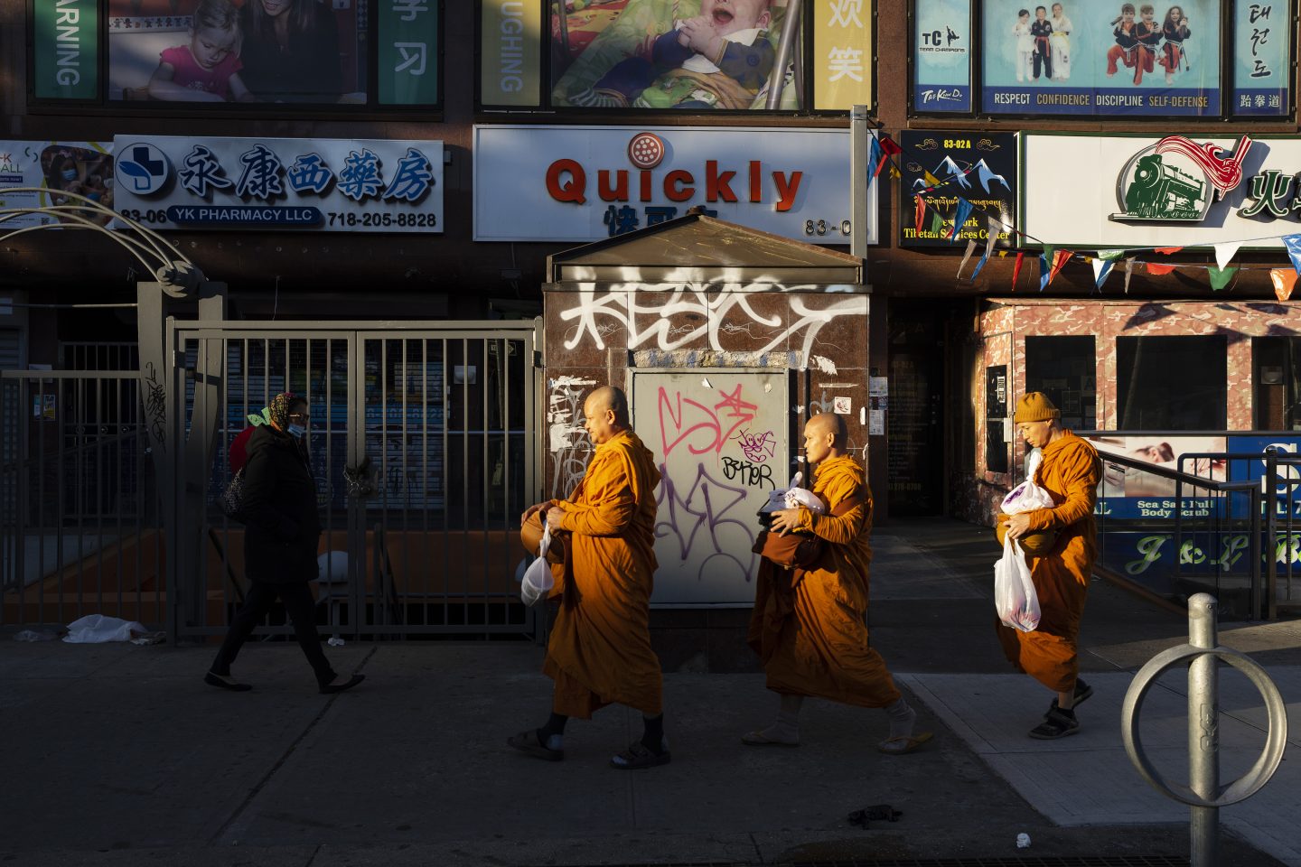 Three monks walking through an urban streetscape, featured for Advanced Mentored Studies in visual storytelling and documentary photography.
